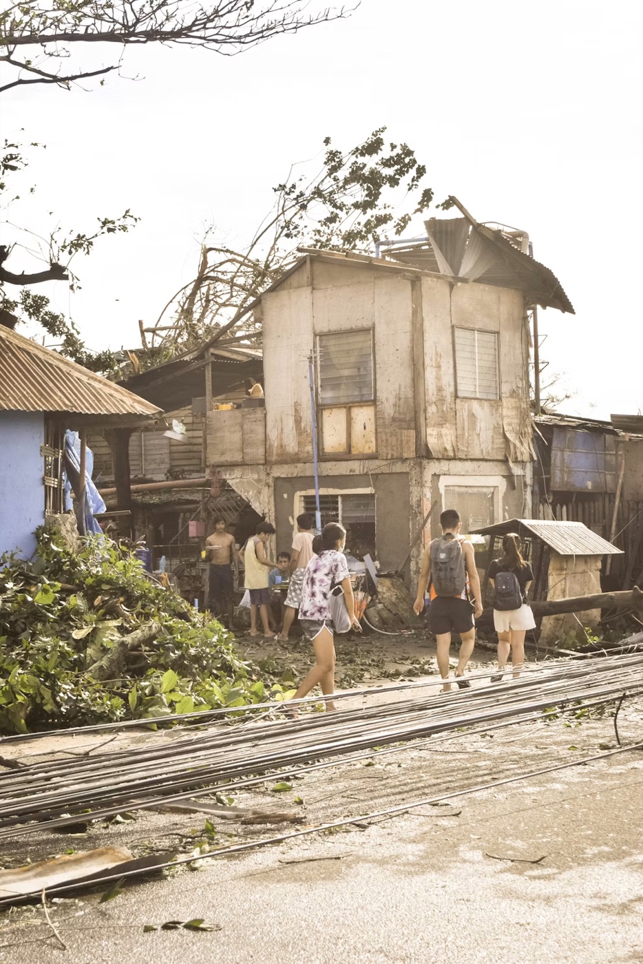 People walking through a community damaged by a severe storm