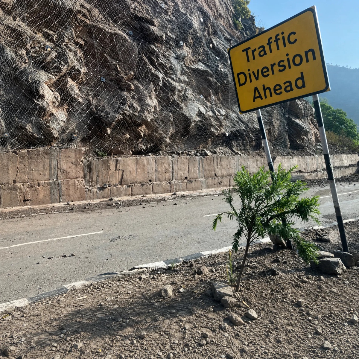 Traffic diversion sign beside a protected hillside road in Una